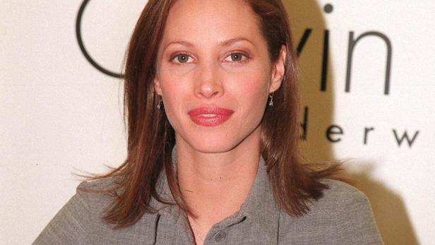 Christy Turlington posiert vor einem Calvin Klein Underwear Logo.