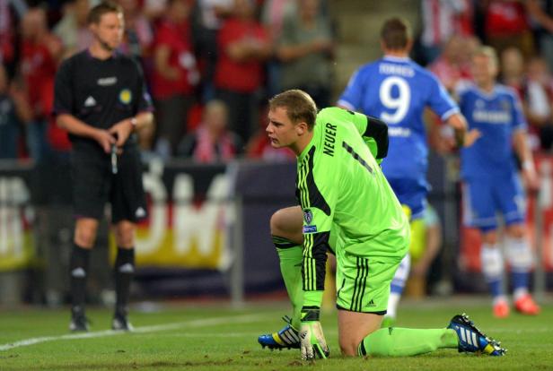 Manuel Neuer kniet während eines Fußballspiels auf dem Rasen.