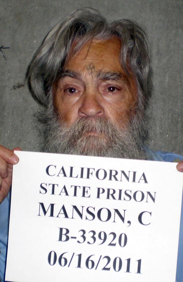 Ein Porträt von Charles Manson, der ein Schild der California State Prison vom 16.06.2011 hält.