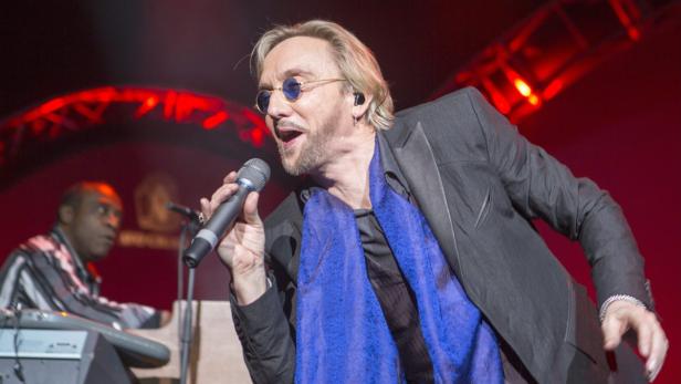 Joe Lynn Turner singt während eines Konzerts in ein Mikrofon.