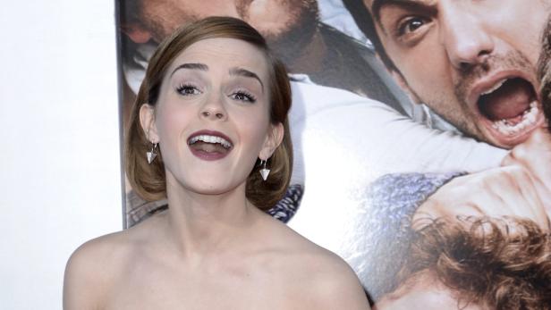 Emma Watson posiert auf dem roten Teppich vor einem Filmposter.