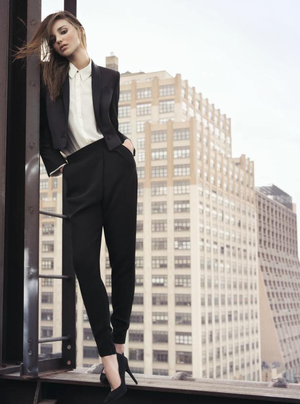 Miranda Kerr posiert auf einem Dach in einem schwarzen Hosenanzug.
