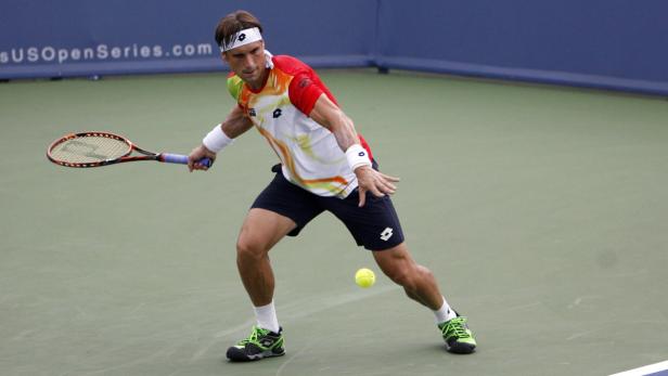 Ein Tennisspieler schlägt einen Ball auf einem Tennisplatz.