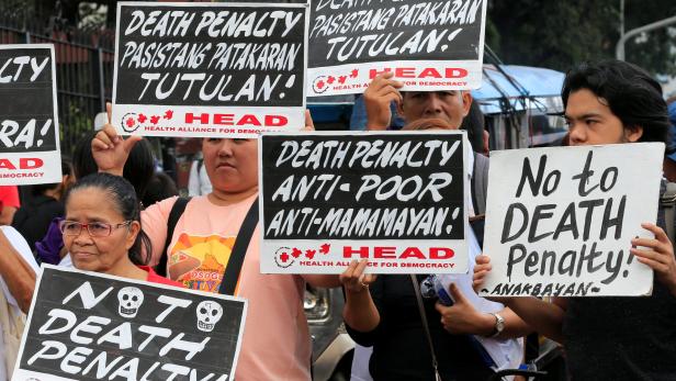 Activists holds placards during a protest rally ag
