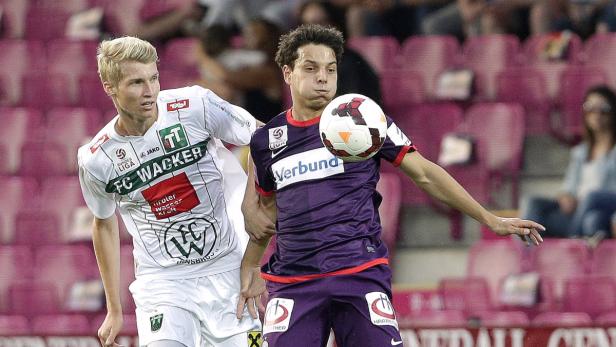Zwei Fußballspieler kämpfen um den Ball während eines Spiels.
