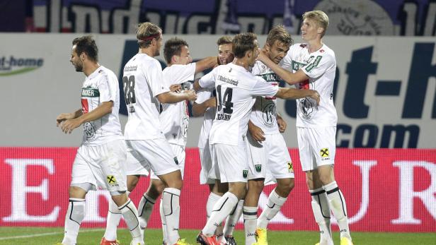 Eine Gruppe Fußballspieler von Wacker Innsbruck feiert gemeinsam auf dem Spielfeld.