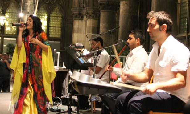 Eine Sängerin tritt mit ihrer Band auf einer Bühne auf.