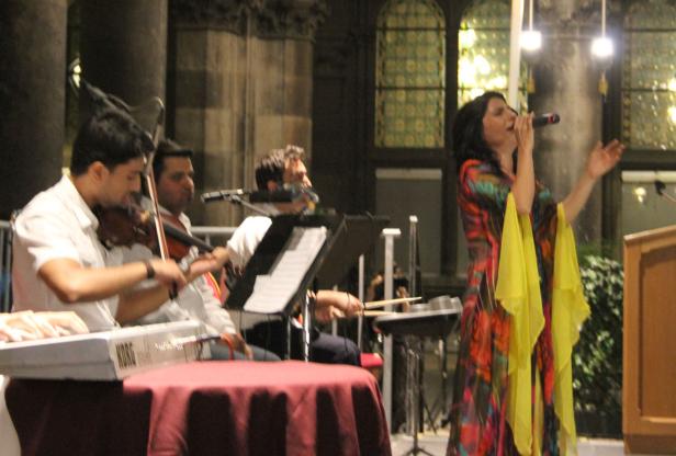 Eine Sängerin tritt mit einer Band auf der Bühne auf.