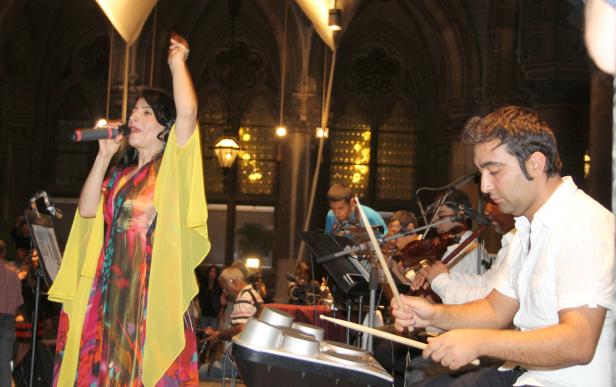 Eine Sängerin tritt mit ihrer Band auf einer Bühne auf.