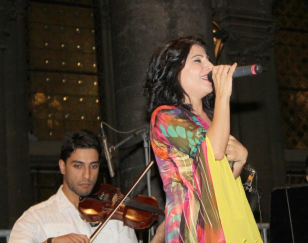 Eine Sängerin tritt mit einem Geiger auf der Bühne auf.