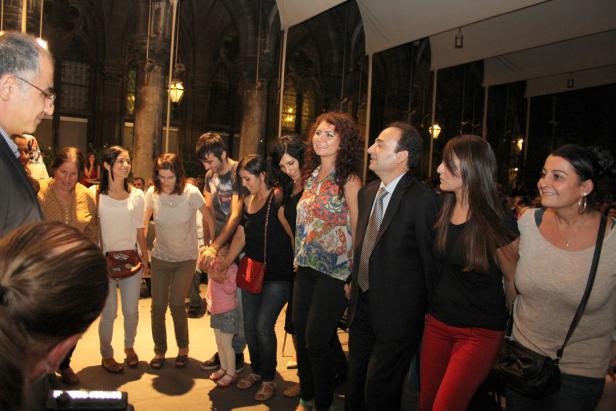 Eine Gruppe von Menschen hält Händchen und scheint zu tanzen.