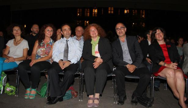 Eine Gruppe von Menschen sitzt bei einer Veranstaltung im Freien.