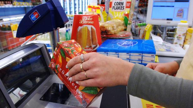 Eine Person scannt eine Packung Früchtetee an einer Supermarktkasse.