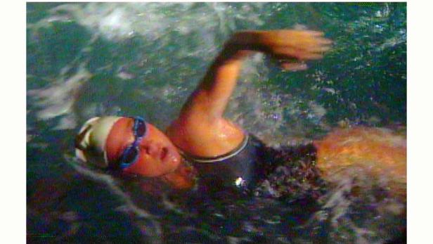 Eine Schwimmerin mit Badekappe und Schwimmbrille im Wasser.