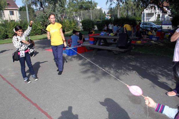 Eine Frau und ein Mädchen lassen einen Ballon an einer langen Schnur steigen.