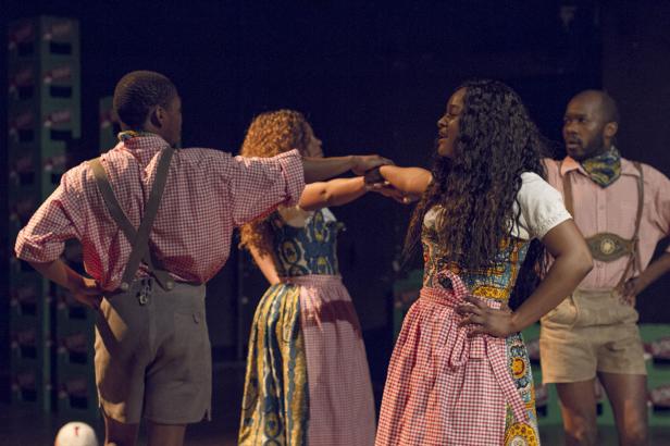 Eine Gruppe von Personen in Trachten steht auf einer Bühne.