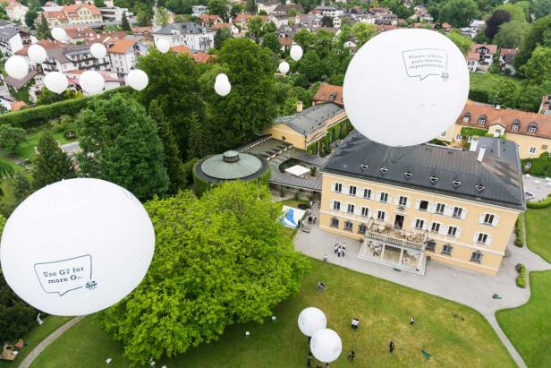 Luftaufnahme von Schloss Elmau mit weißen Ballons, die Botschaften tragen.