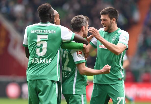 Mehrere Werder Bremen-Spieler feiern gemeinsam auf dem Fußballfeld.