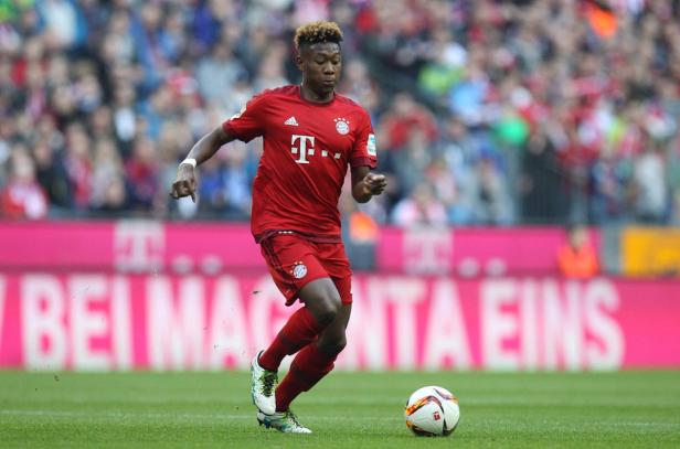 David Alaba im roten Trikot des FC Bayern München am Ball.