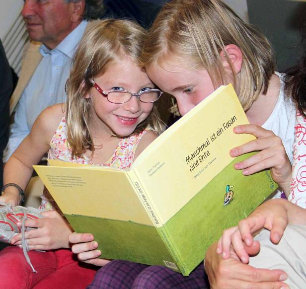 Zwei Mädchen lesen gemeinsam das Buch „Manchmal ist ein Fasan eine Ente“.