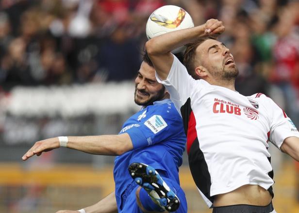 Zwei Fußballspieler kämpfen bei einem Spiel um den Ball.