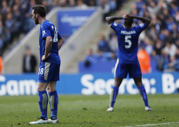 Zwei Fußballspieler in blauen Trikots stehen auf dem Spielfeld.