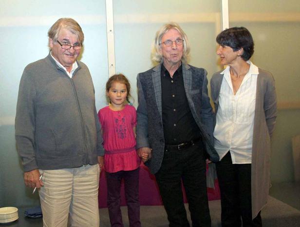 Eine Gruppe von vier Personen, darunter ein Kind, stehen nebeneinander.