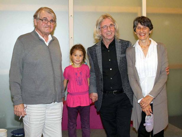 Eine Gruppe von vier Personen, darunter ein kleines Mädchen, posiert für ein Foto.