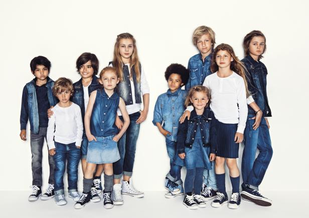 Eine Gruppe von Kindern posiert in Jeanskleidung vor einem weißen Hintergrund.