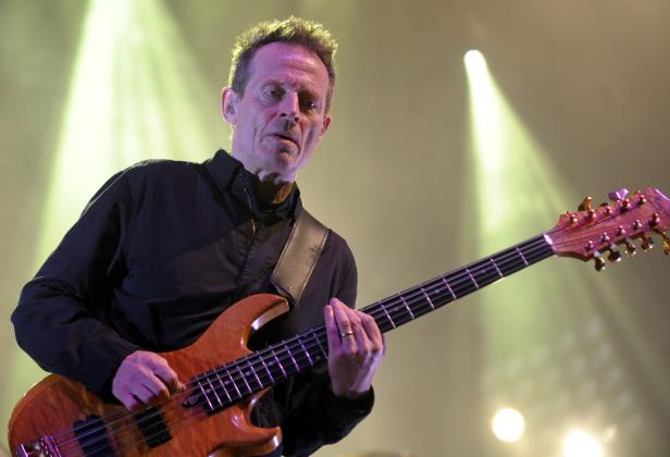 Ein Mann spielt unter Scheinwerferlicht auf einem E-Bass.