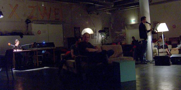 Ein Mann spricht bei einer Veranstaltung in ein Mikrofon.