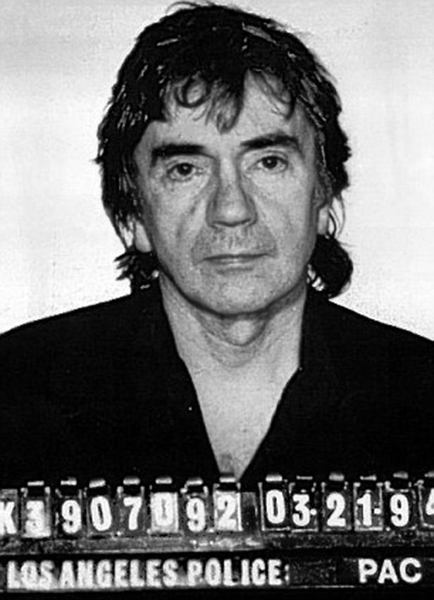 Ein Schwarzweiß-Porträt von John Phillips von The Mamas & the Papas als Polizeifoto.