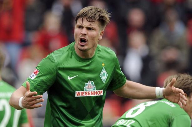 Ein Fußballspieler von Werder Bremen gestikuliert während eines Spiels.