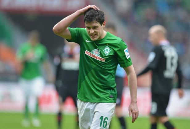 Ein Fußballspieler von Werder Bremen greift sich an den Kopf.