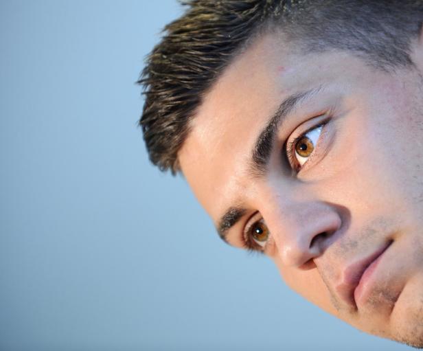 Nahaufnahme des Gesichts eines jungen Mannes mit braunen Augen.