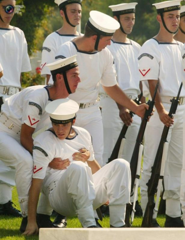 Ein Marinekadett wird während einer Parade von einem Kameraden gestützt.