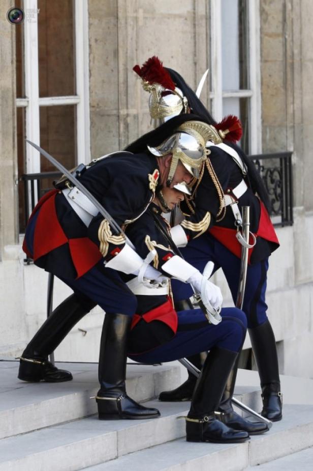 Zwei Gardesoldaten in Paradeuniform mit Säbeln auf einer Treppe.