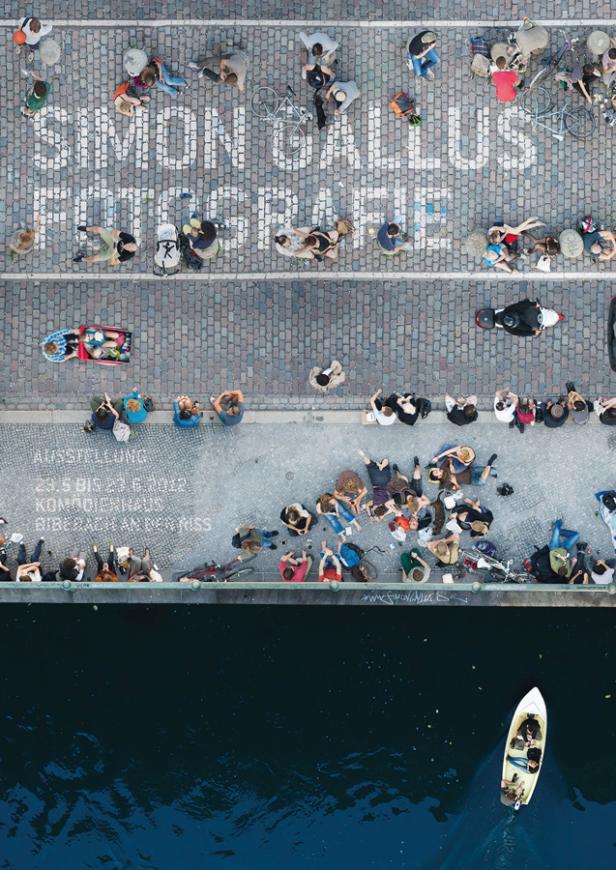 Eine Menschenmenge versammelt sich auf einem Platz mit der Aufschrift „Simon Gallus Fotografie“.