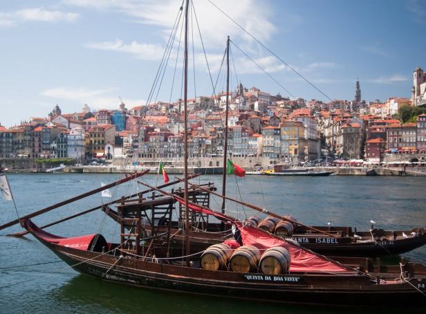 Traditionelle Weintransportboote liegen vor der Altstadt von Porto vor Anker.