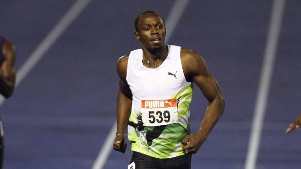 Usain Bolt beim Laufen auf einer blauen Laufbahn.