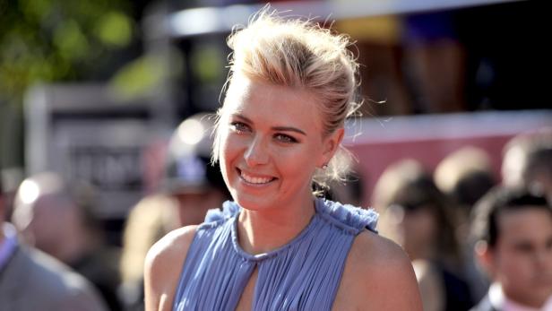 Maria Sharapova lächelt auf einem roten Teppich.