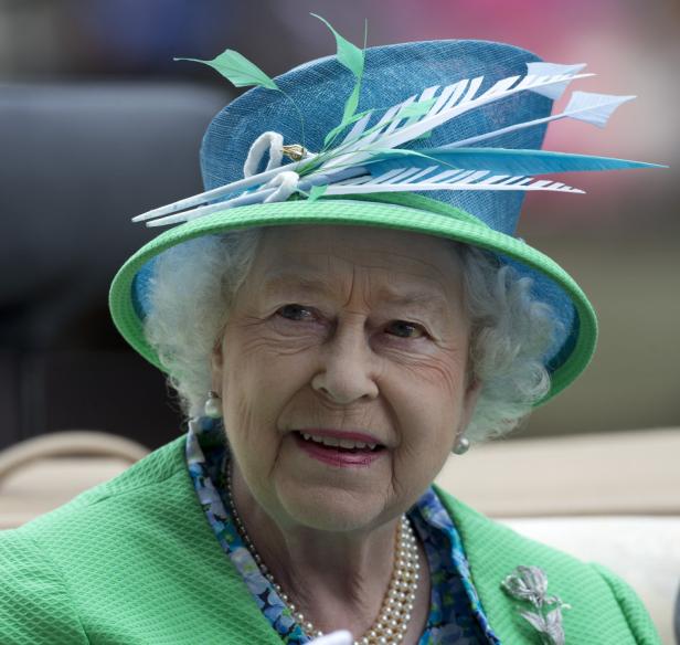 Königin Elisabeth II. mit einem blau-grünen Hut und einem grünen Blazer.