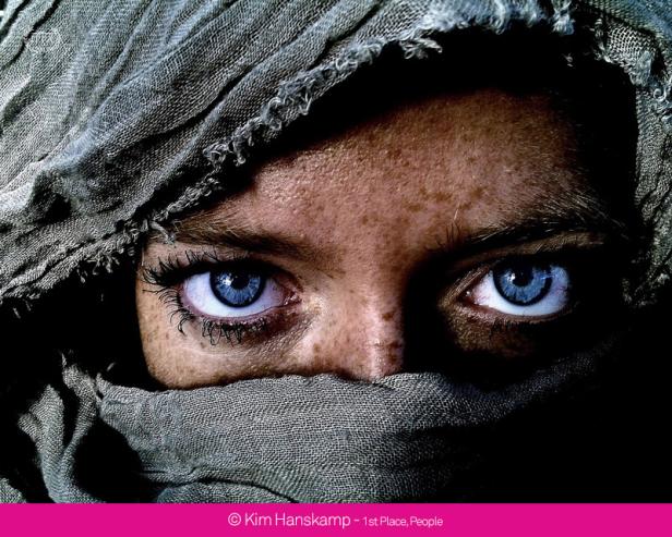 Das Gesicht einer Frau mit hellblauen Augen ist von einem Schleier bedeckt.