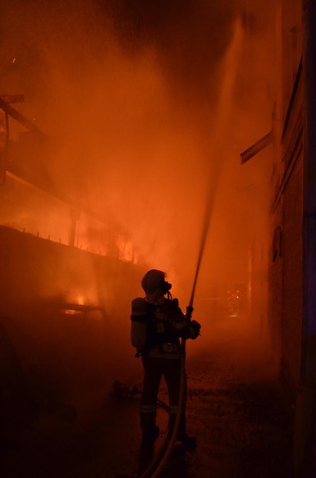 Ein Feuerwehrmann löscht ein Feuer in einem Gebäude.