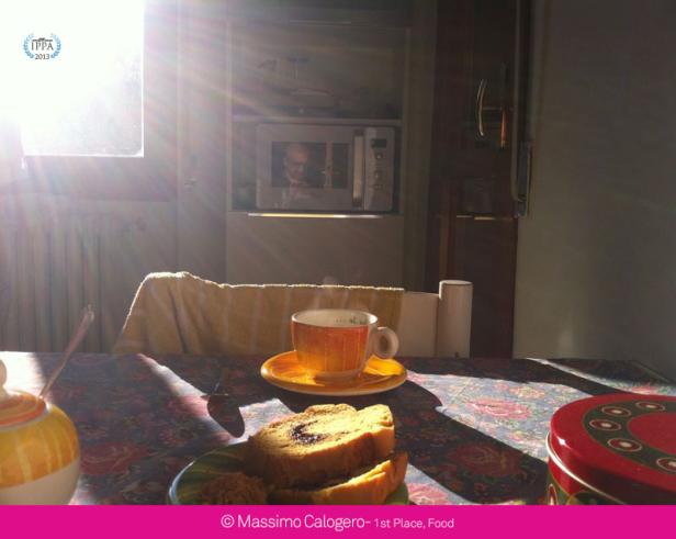 Ein gedeckter Tisch mit Kuchen, einer Tasse Tee und einer Person, die sich im Mikrowellenherd spiegelt.