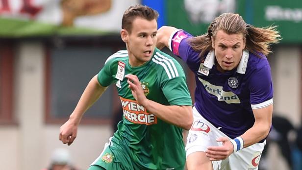 Zwei Fußballspieler im Zweikampf während eines Spiels.