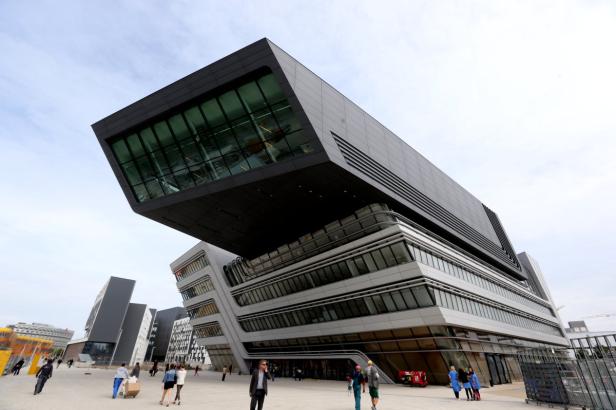 Die Bibliothek und das Lernzentrum der Wirtschaftsuniversität Wien mit Passanten im Vordergrund.