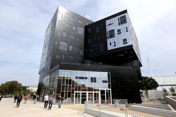 Das Hauptgebäude der Wirtschaftsuniversität Wien mit Passanten im Vordergrund.
