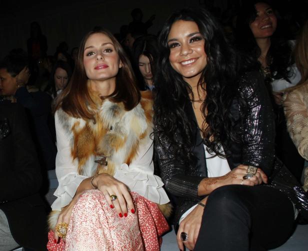Olivia Palermo und Vanessa Hudgens sitzen nebeneinander bei einer Veranstaltung.