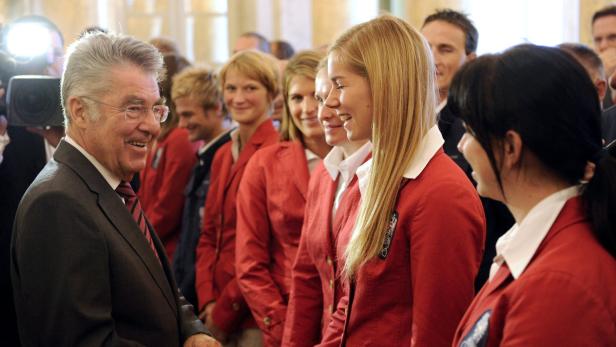 Heinz Fischer im Gespräch mit einer Gruppe junger Sportler in roten Jacken.